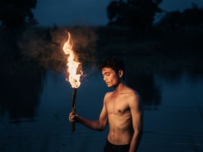 Silhouette of a person in a balancing pose against a dark background.